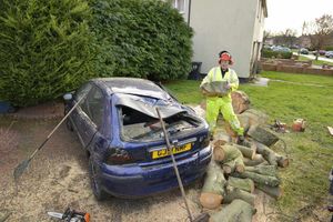 Shropshire Council worker Perry Muir clears away debris after a tree fell on a car in Pool Rise, Shrewsbury. 