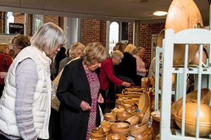 Visitors look at a selection of hand-turned bowls at an event