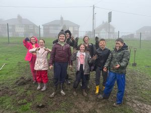 Pupils from Clee Hill Community Academy celebrating the end of the mucky task of crocus corn plating