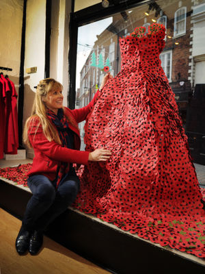 Taking a look at the window display dress, created from poppies, retail assistant Jo-Anna Maple of Church Stretton, at Marianne Exclusive Fashions, Shrewsbury in 2017