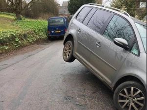 Supporting image for story: Driver leaves vehicle parked in midair on hilly rural lane
