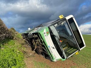 Supporting image for story: Bus with 10 passengers ends up on its side in field after driver forced to take 'evasive action'