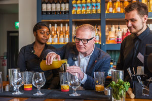 Students Tamara Pinnock (left) and Shane Masters (right), showing the Mayor Richard Parker (centre), the art of cocktail making at All Bar One. PIC: West Midlands Combined Authority