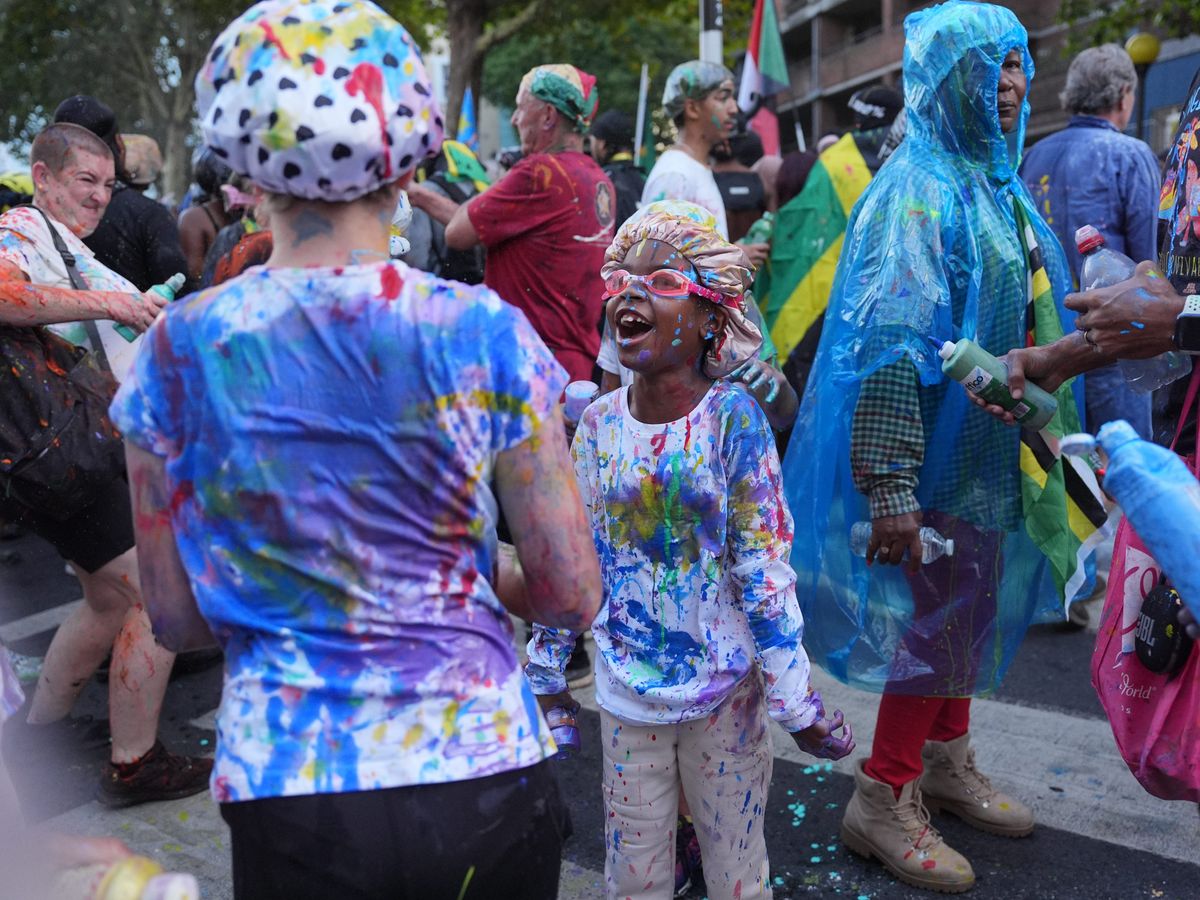 Carnival revellers squirt paint as part of colourful Caribbean celebration