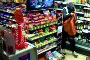 One of the men stuffs alcohol into his bag