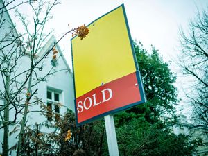 A sold sign in front of a property