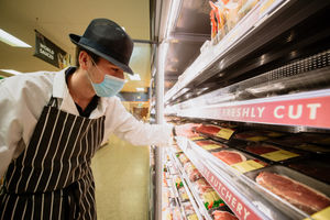Butcher Jack Nicholas making sure the meat shelves are stocked up