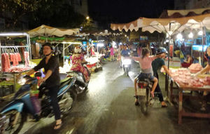 Mopeds rush around fresh food stalls in downtown Saigon