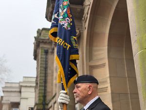 A military veteran holds a flag during the flag-raising ceremony for Commonwealth Day 2026.
