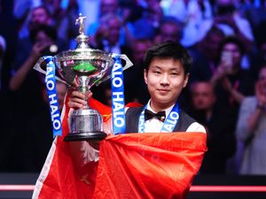 Zhao Xintong lifts the trophy after winning the World Snooker Championship 2025