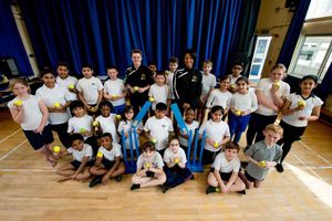 Sports coaches Greg Warren and Marisa Martin with youngsters from Woden Primary School
