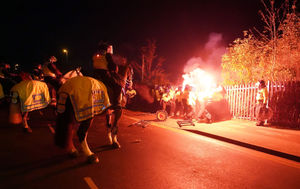 Police attempt to put out flares thrown towards them outside Villa Park. Photo: David Davies/PA Wire