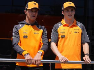 Lando Norris left, is flanked by his teammate Oscar Piastri in the paddock