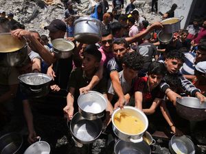 Palestinians struggle to get donated food at a community kitchen