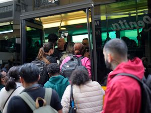 People try to board a crowded bus in Lisbon, Portugal, after the subway stopped running because of a power cut