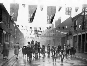PICTURE FROM THE ARCHIVE: Children celebrating following Victory in Europe Day in May 1945. This image was taken in Gordon Street, Wolverhampton, with locals out on the street despite a rain shower. Like many streets across the Black Country, patriotic bunting was stretched between houses. 