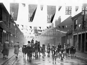 PICTURE FROM THE ARCHIVE: Children celebrating following Victory in Europe Day in May 1945. This image was taken in Gordon Street, Wolverhampton, with locals out on the street despite a rain shower. Like many streets across the Black Country, patriotic bunting was stretched between houses. 