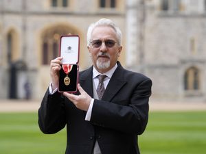 Sir Alan Hollinghurst shows off the medal he received to mark being knighted