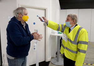 Walsall councillor Chris Towe checks Neil Smith's temperature