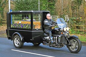 Sandy Duncombe's coffin arrives at her funeral in a motorbike-powered hearse. Around 100 motorcyclists rode in convoy