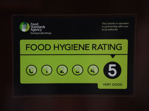 A Food Standards Agency rating sticker on a window of a restaurant