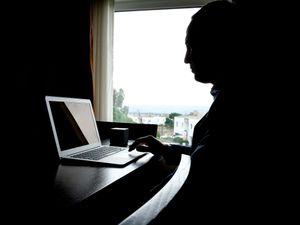 Silhouette of a man using a laptop