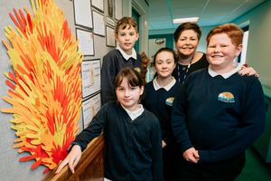 Assistant principal Ffion Carr with pupils Georgia Fallows 10, Elle Smith 10, Tom Searle 10, and Benjamin Carr, 11, with a flame made from hand prints to symbolise standing together