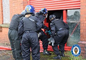 Police officers executing a drugs warrant in a derelict Territorial Army building in Tipton on Tuesday.