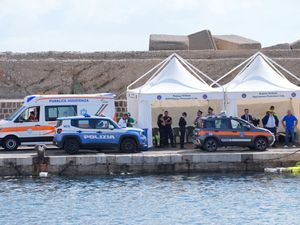 Italian emergency services vehicles and tents at a harbour