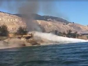 Supporting image for story: A couple in Canada used their speedboat to try to put out a fire on the bank of a river