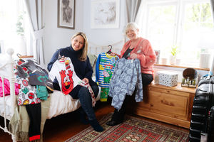 Tracy Van Mook and Coral Parker preparing clothes and a bedroom ready for their guests at Tracy's home