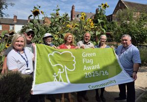 Sarah Clarke, Steve Breeze, David Lawrence, Anna Webster, Mohamed Arif, Estelle Fisher and Cllr Adrian Andrew celebrate by raising the Green Flag.