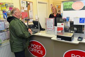 Post Office supervisor Lorraine Edwards serves a customer