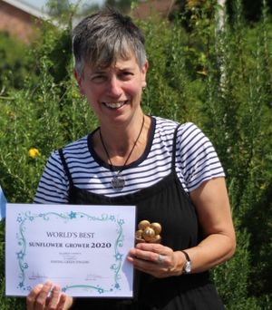 Teresa Dawkes, winner of the sunflower growing competition, with her certificate and trophy