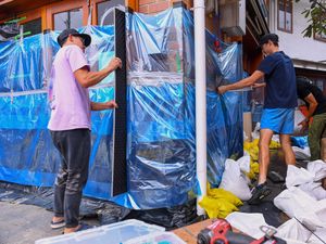 Owners work to protect their cafe with sandbags and plastic sheets in the Brisbane suburb of Rosalie, Australia