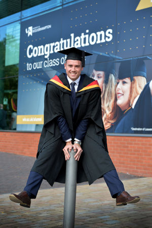 Kristian Thomas celebrates after receiving his degree