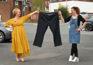Sarah holding a pair of her old jeans, with (left) Slimming World consultant Michelle Bishop