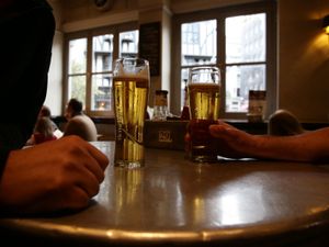 Patrons with their drinks at a table in a pub