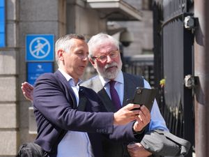 Former Sinn Fein president Gerry Adams poses for a photograph with a member of the public outside the High Court in Dublin