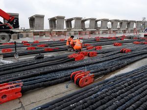 Engineers can be seen working on the cable strays that keeps the structure together