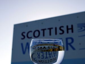 Scottish Water logo pictured through a glass of water