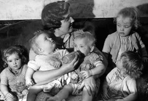 October 12, 1953, the caption reads: 'Five babies within 12 months is the proud record of 28-year-old Mrs Ivy Bourne, of 57 Valley Road, Walsall, now a mother of nine. In November 1951 triplets (Jean, Rosamund and Margery) were born followed by twins (Vera and Leslie) in November 1952. here is Mrs Bourne with the twins and triplets.'