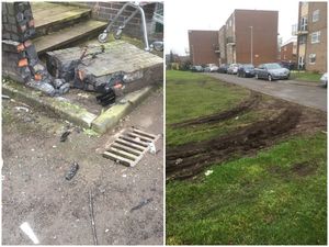 A damaged wall at the scene in St John Street with tyre marks on a nearby grassed area
