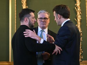 Volodymyr Zelensky, left, embracing Emmanuel Macron, right, with Sir Keir Starmer standing close by in the middle