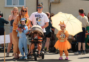 Representing TV cartoon character Bluey were mum Stacey Lloyd, Jacob, eight, dad Harley Lloyd, Rosie, five under the umbrella and Phoebe, one and a half in the pram. Image Andy Compton