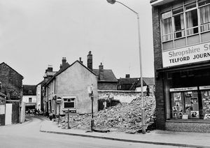 Tan Bank in August 1973. The caption pasted on the back of the print reads: 'Demolition work has started on old property in Tan Bank, Wellington, preparing the way for rear service access to premises in New Street as part of the pedestrian-only plan for Wellington centre. This, coupled with the new ring road, will provide traffic-free shopping in New Street, the Square, and Market Street areas.'