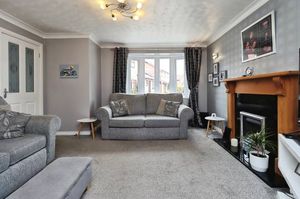 The living room has an attractive modern feature fireplace and a lovely bay window to the front
