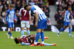 Brighton and Hove Albion's Lewis Dunk (top) looks down at an injured Aston Villa's Ollie Watkins