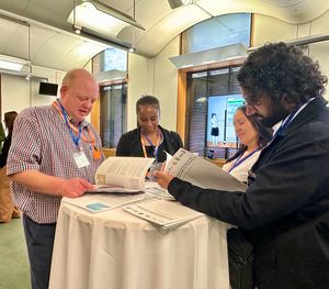 Mike Crump, resident; Collette Eden, resident; and Engagement Officers Linda Edwards and Satinder Singh reading the new journey planner designed with their input