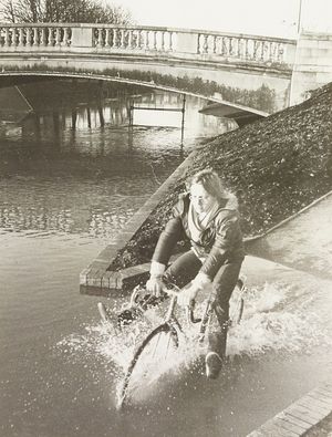 A major flood prevention scheme on the River Sow had been completed by Severn Trent Water Authority just a few months before heavy rain, meaning that only certain areas such as Victoria Park in Stafford had been flooded. The photograph shows Peter Owen trying to get through the floods on his bicycle. December 1979.
